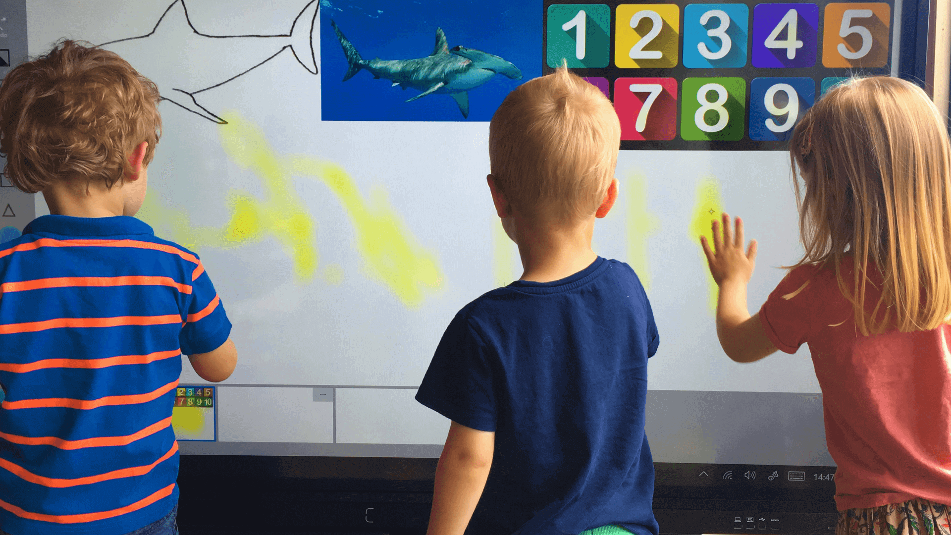 A group of kids interacting with a touch screen