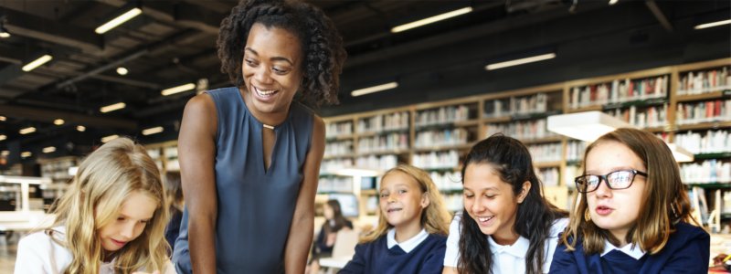 Teacher interacting with students in a library